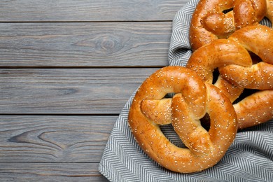Photo of Tasty freshly baked pretzels on wooden table, flat lay. Space for text
