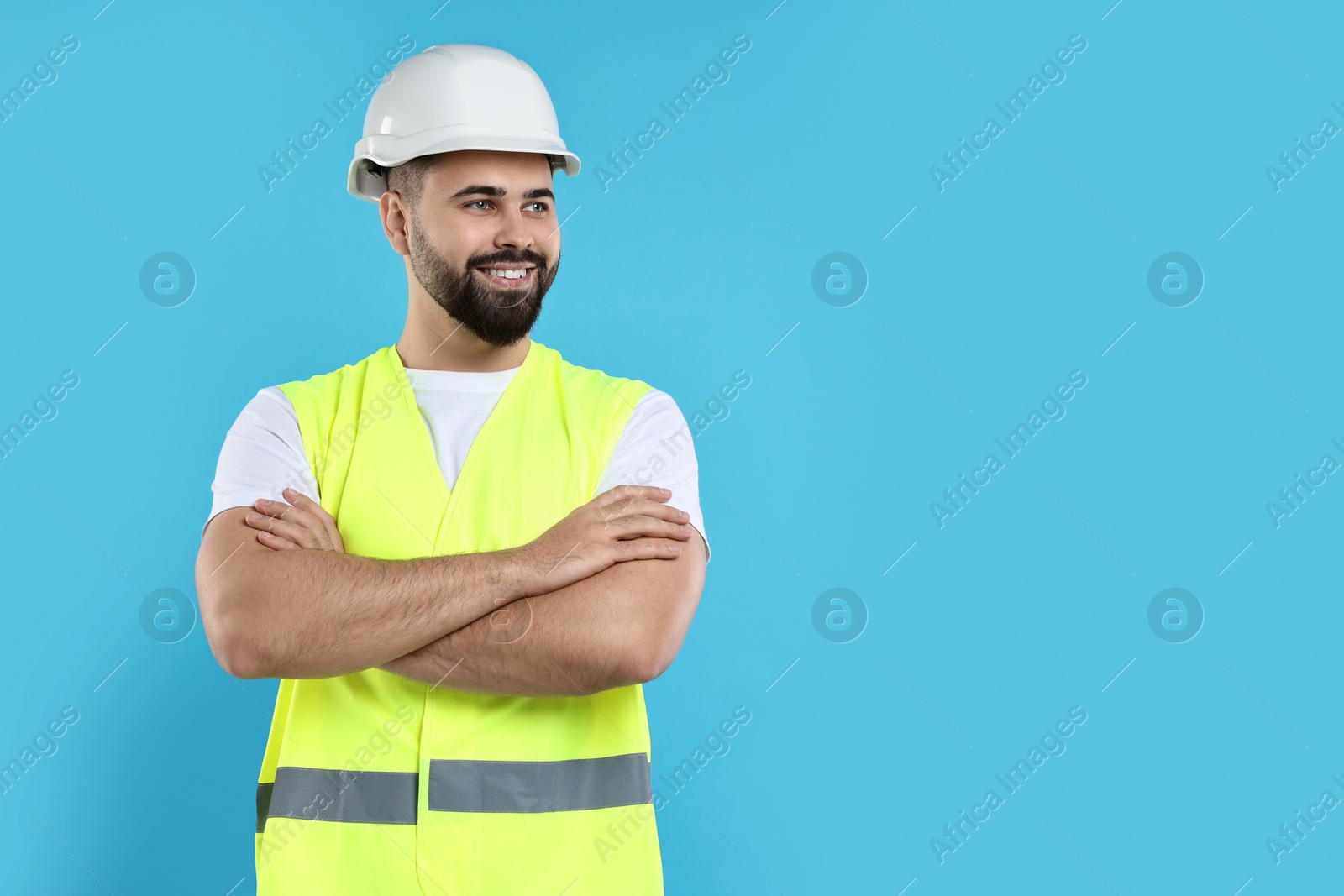 Photo of Engineer in hard hat on light blue background, space for text