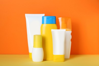 Set of different suntan products on color background