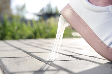 Woman stepping in chewing gum on sidewalk. Concept of stickiness