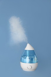 Photo of Modern air humidifier on light blue background
