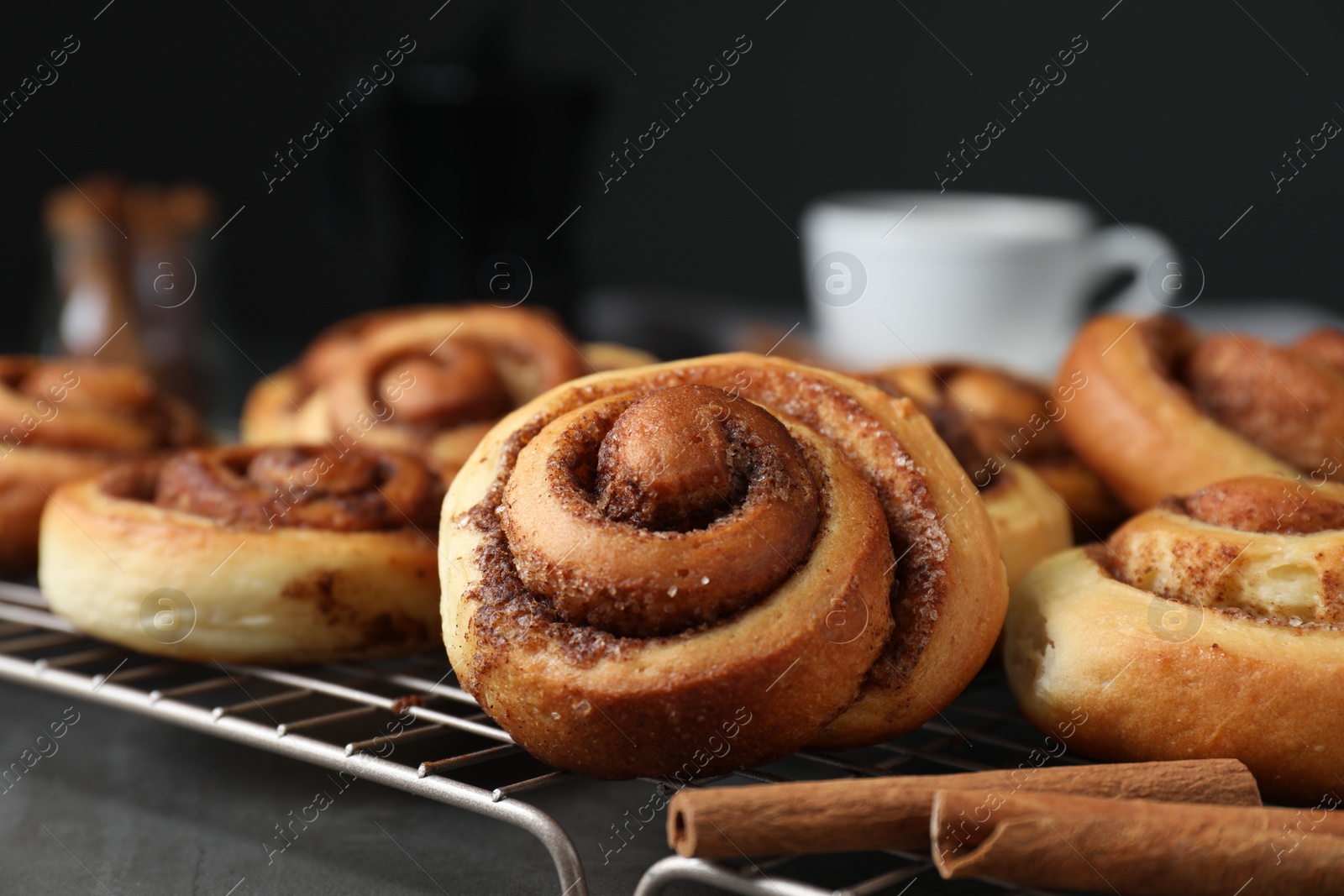 Photo of Tasty cinnamon rolls on black table, closeup. Space for text