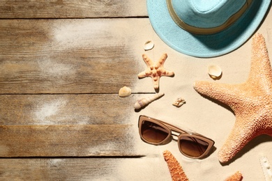 Photo of Flat lay composition with beach objects, sand and space for text on wooden background