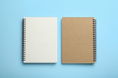 Photo of Notebooks on light blue background, top view. Space for text