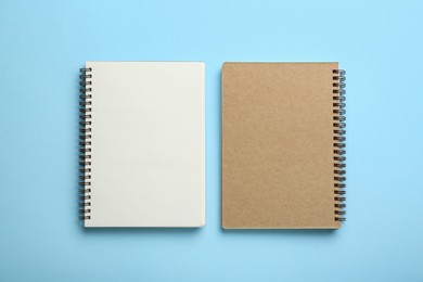 Notebooks on light blue background, top view. Space for text