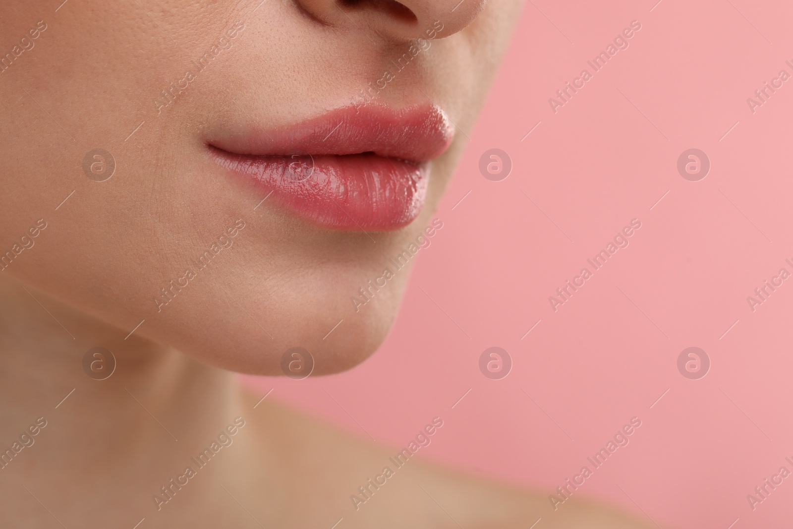 Photo of Young woman with beautiful full lips on pink background, closeup