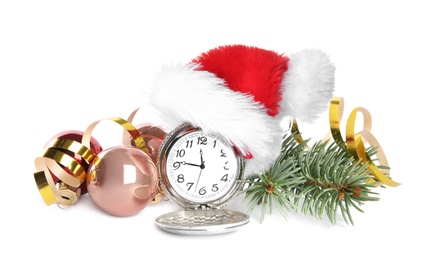 Photo of Pocket watch with Santa hat and festive decor on white background. New Year countdown