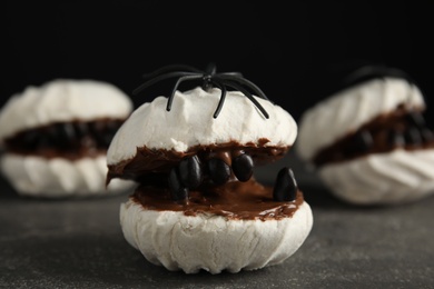 Photo of Delicious desserts decorated as monsters on grey table. Halloween treat