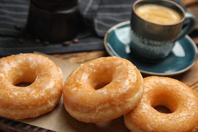 Sweet delicious glazed donuts on table, closeup