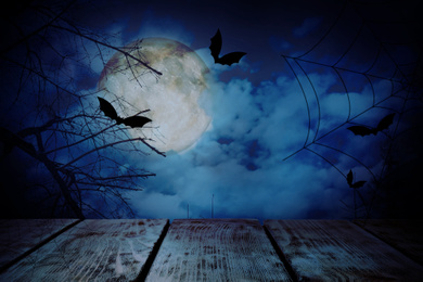 Image of Wooden surface and bats flying in night sky with full moon. Halloween illustration