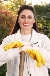 Photo of Woman wearing gloves and having rest after working in garden