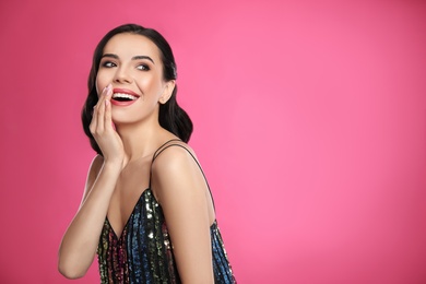 Photo of Portrait of surprised woman on pink background, space for text