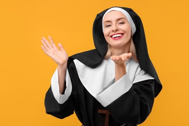 Photo of Happy woman in nun habit against orange background