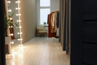 Photo of Dressing room with clothes rack and mirror. Interior design