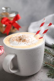 Cup of delicious eggnog with cinnamon on gray table, closeup