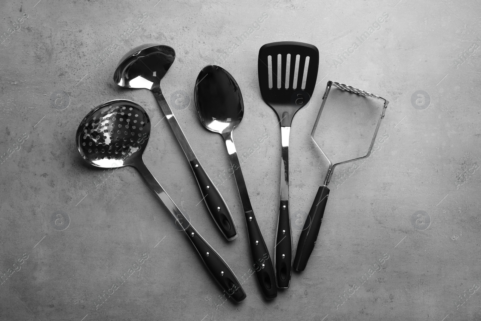 Photo of Set of different kitchen utensils on grey background, top view