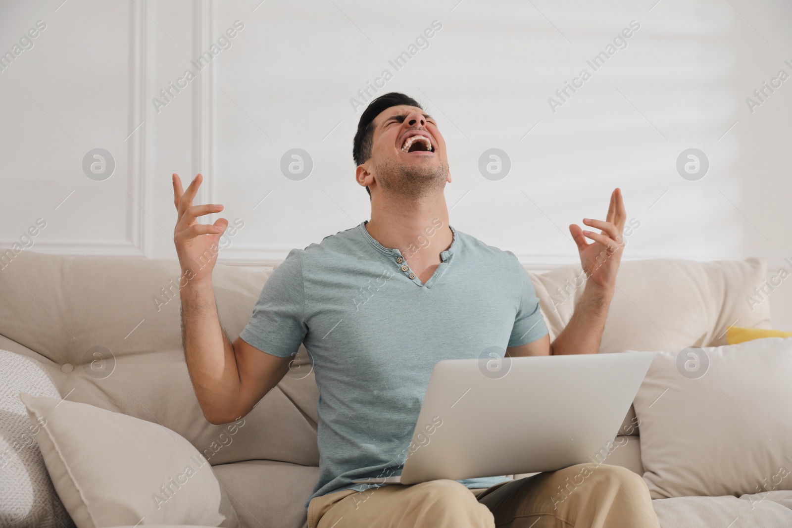 Photo of Emotional man working with laptop at home