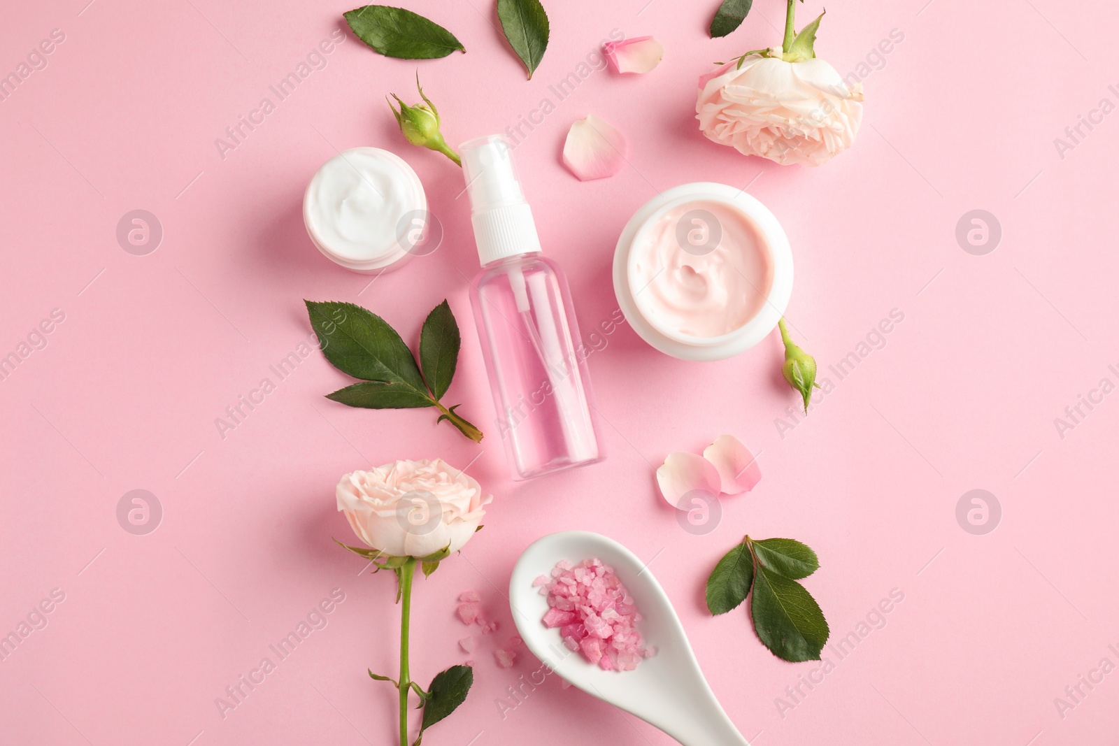 Photo of Flat lay composition with rose essential oil on pink background