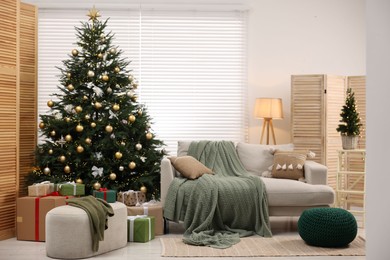 Christmas tree in room decorated for holiday. Festive interior design