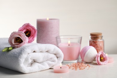 Photo of Beautiful composition with burning candles and different spa products on white table