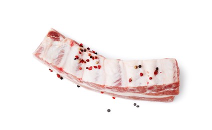 Raw pork ribs with peppercorns isolated on white, top view