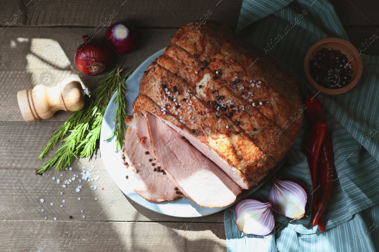 Photo of Delicious baked ham, onion chili peppers and rosemary on grey wooden table, flat lay