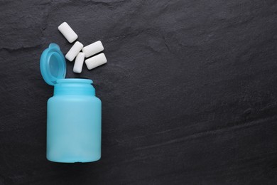 Photo of Jar with chewing gums on black table, flat lay. Space for text