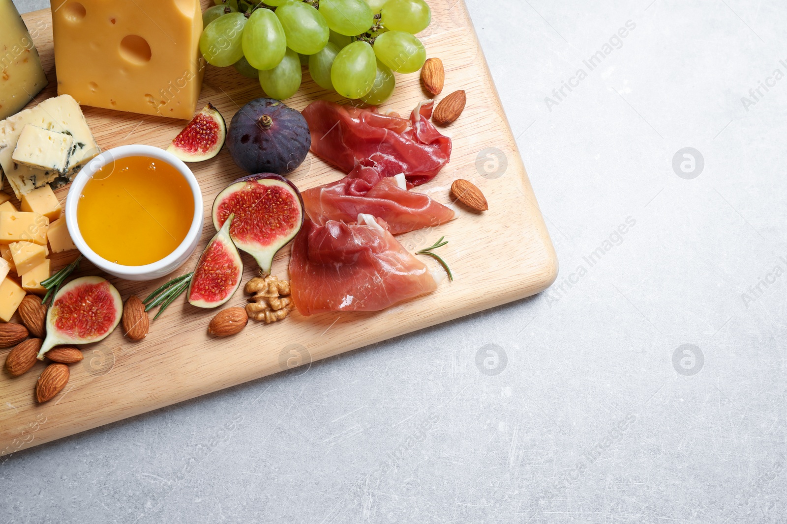 Photo of Set of different snacks with ripe figs served on light table, top view. Space for text