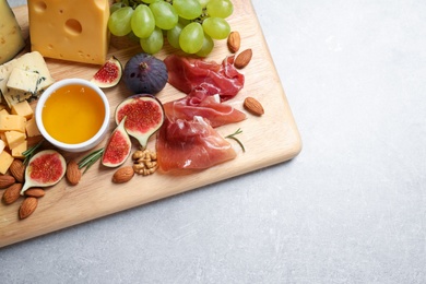 Set of different snacks with ripe figs served on light table, top view. Space for text