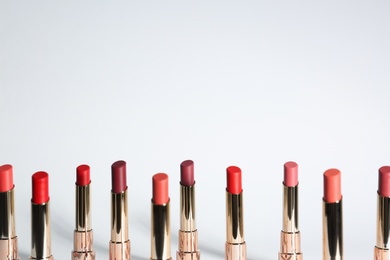 Set of bright lipsticks in gold tubes on white background