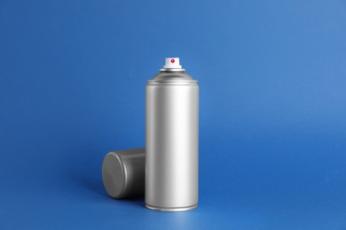 Photo of Can of spray paint on blue background