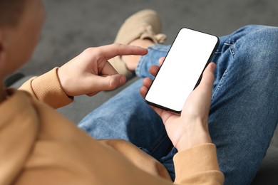 Photo of Man using smartphone with blank screen indoors, closeup. Mockup for design