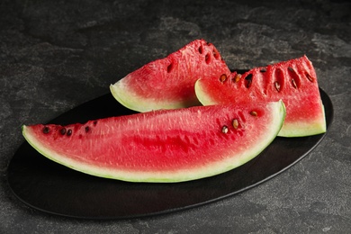 Photo of Yummy watermelon slices on grey table, closeup