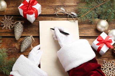 Top view of Santa writing letter at wooden table, closeup