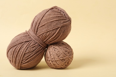 Soft colorful woolen yarns on beige background. Space for text