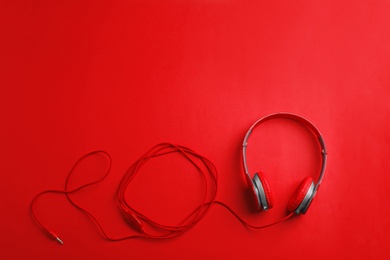 Stylish headphones on color background, top view. Space for text