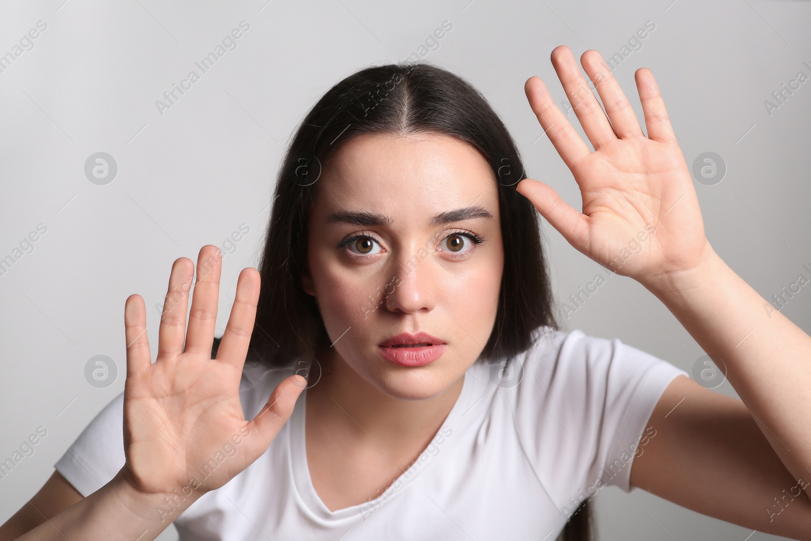 Photo of Young woman stuck to transparent screen. Internet addiction