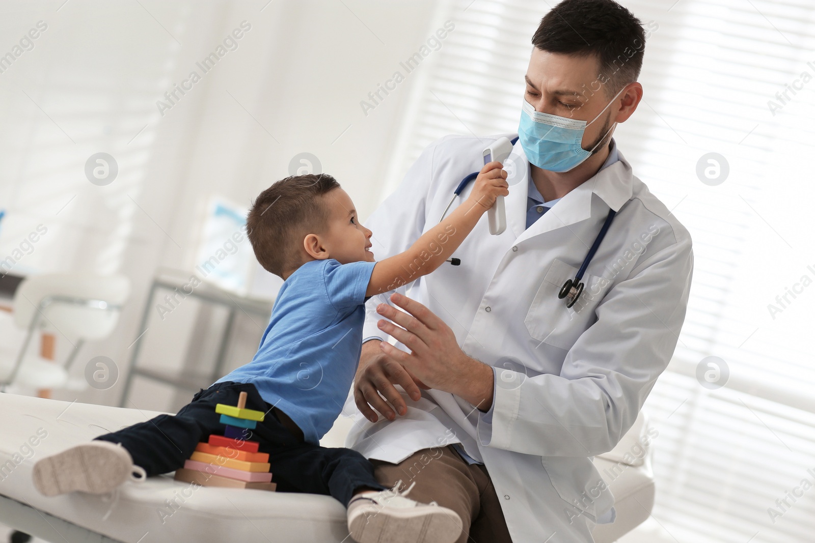 Photo of Pediatrician playing with little boy at hospital