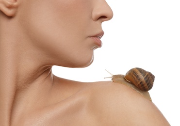 Beautiful young woman with snail on her shoulder 
 against white background, closeup