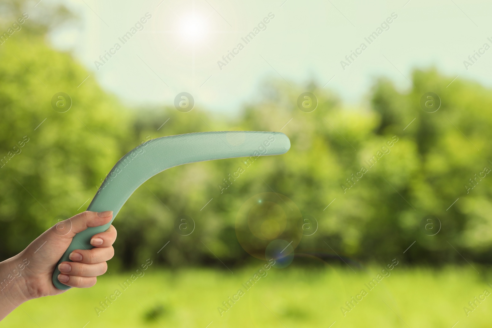 Image of Woman holding boomerang outdoors, closeup. Space for text