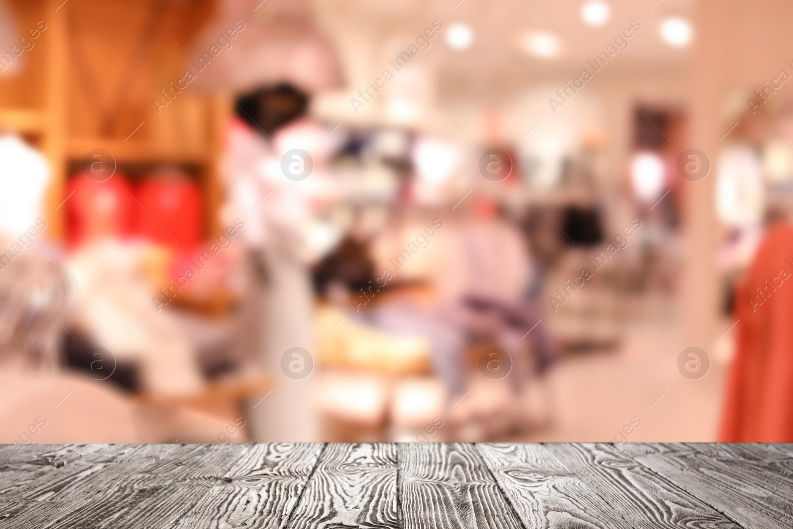 Image of Empty wooden table and blurred view of store with modern clothes