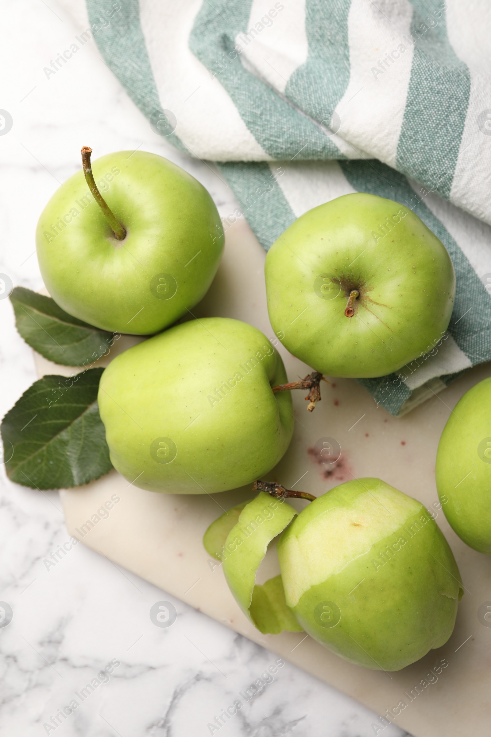 Photo of Ripe green apples and leaves on white marble table, flat lay