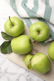 Ripe green apples and leaves on white marble table, flat lay