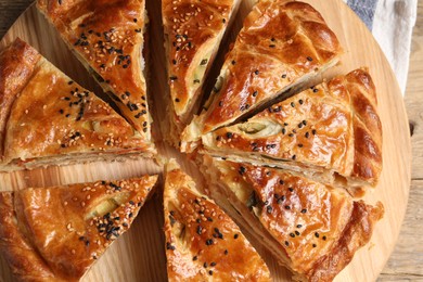 Photo of Cut delicious homemade pie on wooden table, top view