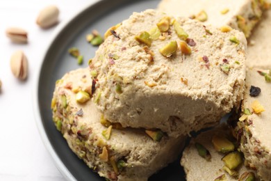 Photo of Tasty pistachio halva on white table, closeup