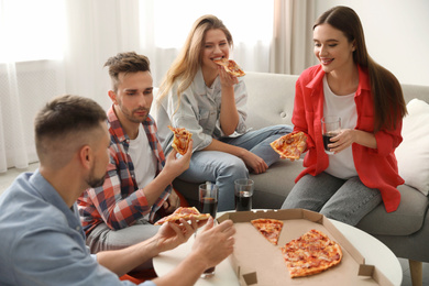 Group of friends eating tasty pizza at home