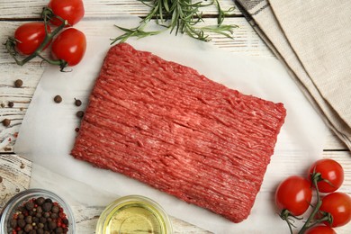 Raw fresh minced meat and other ingredients on white wooden table, flat lay