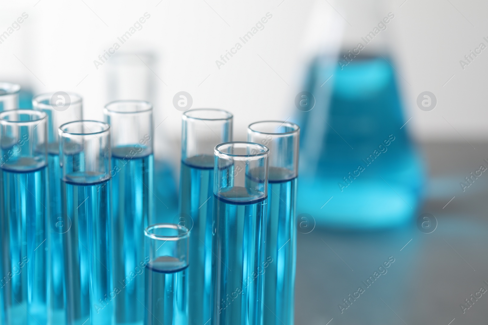 Photo of Test tubes with light blue liquid in laboratory, closeup