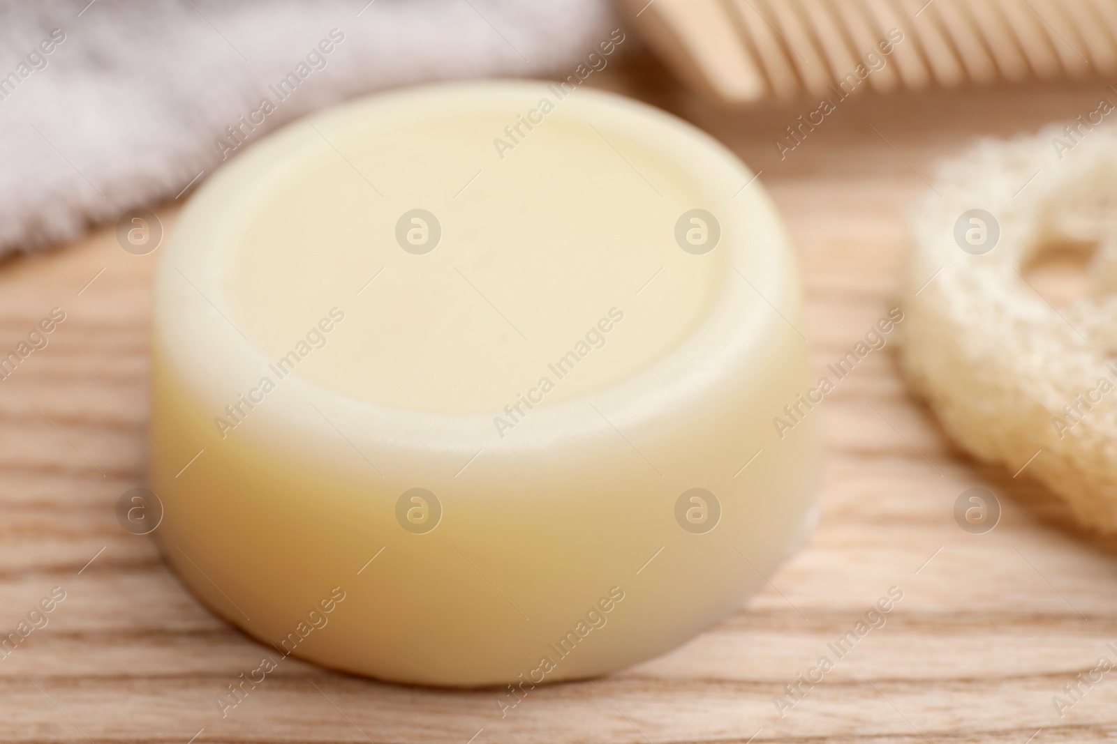 Photo of Solid shampoo bar on wooden table, closeup