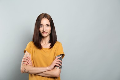 Portrait of pretty young woman with gorgeous chestnut hair on light grey background, space for text